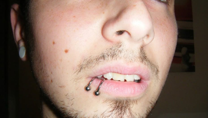 Homme portant deux piercings labret avec anneaux sur la lèvre inférieure chez Atyka Body Works à Toulouse