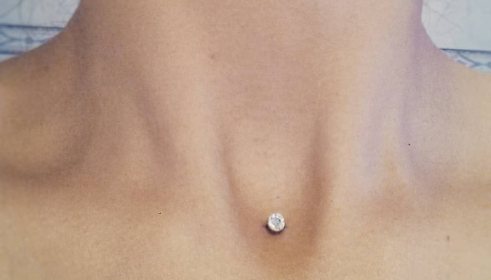 Piercing microdermal avec bijou brillant posé au niveau du décolleté chez Atyka Body Works à Toulouse